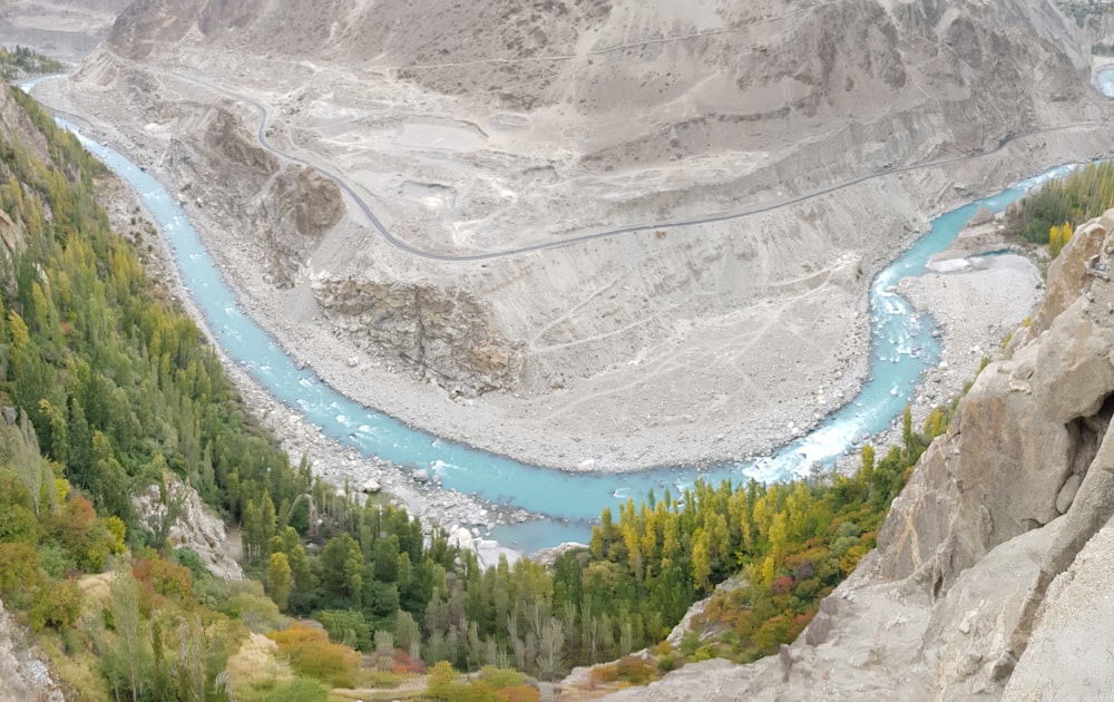 aerial view of lake between trees and rocky mountains during daytime