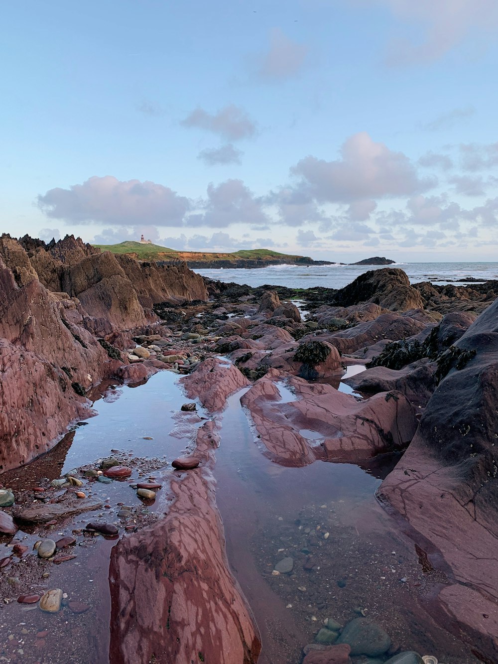 brown rock formation on body of water during daytime