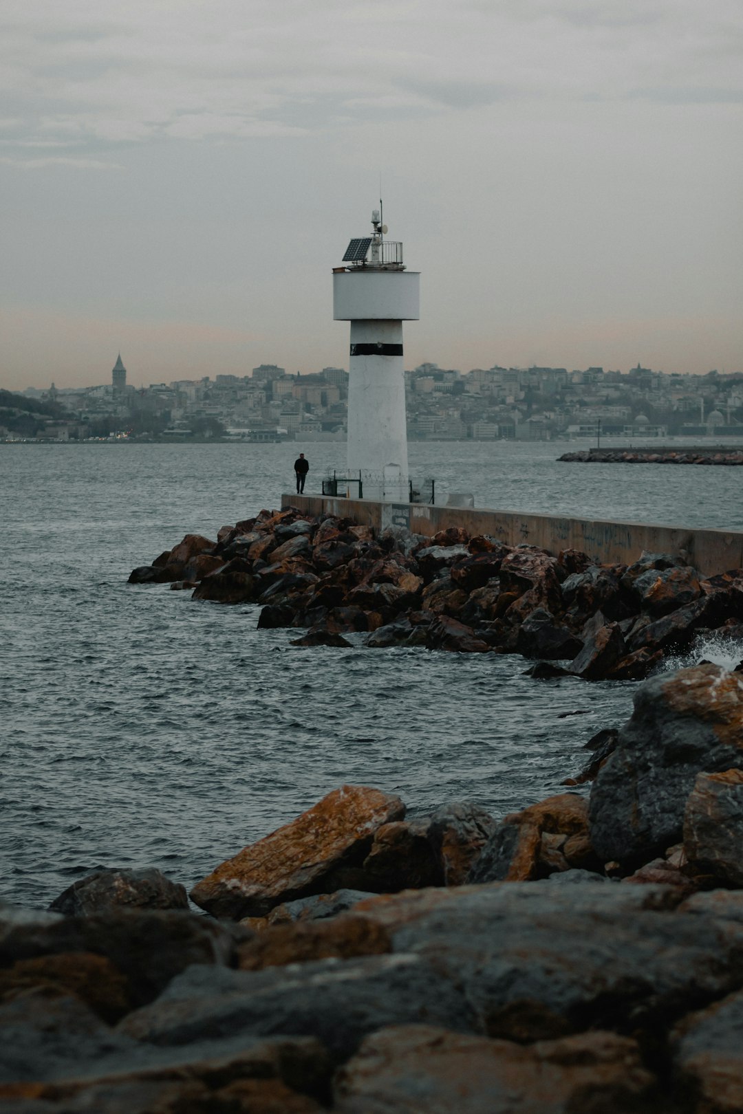 white lighthouse near body of water during daytime