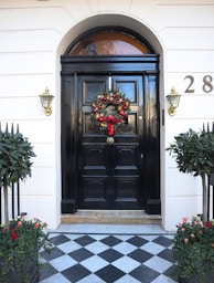 black wooden door with red flowers