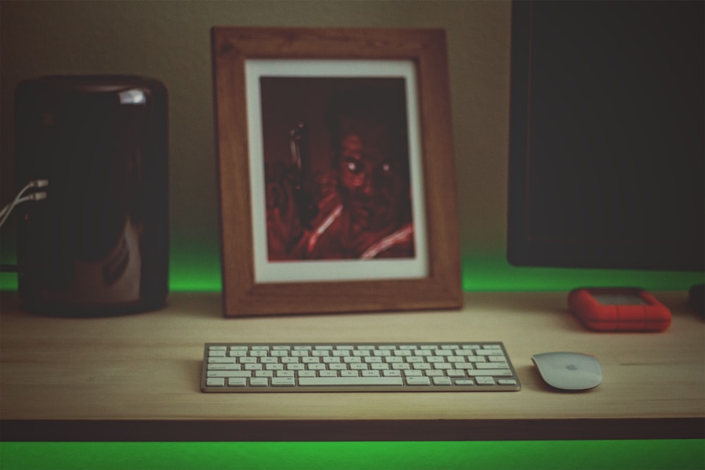 white computer keyboard beside black speaker