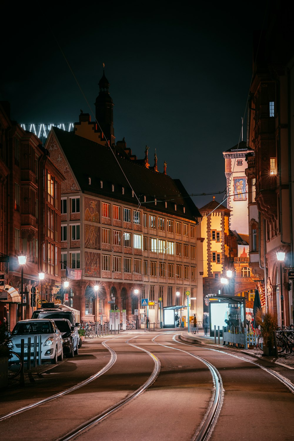 cars parked beside brown concrete building during night time