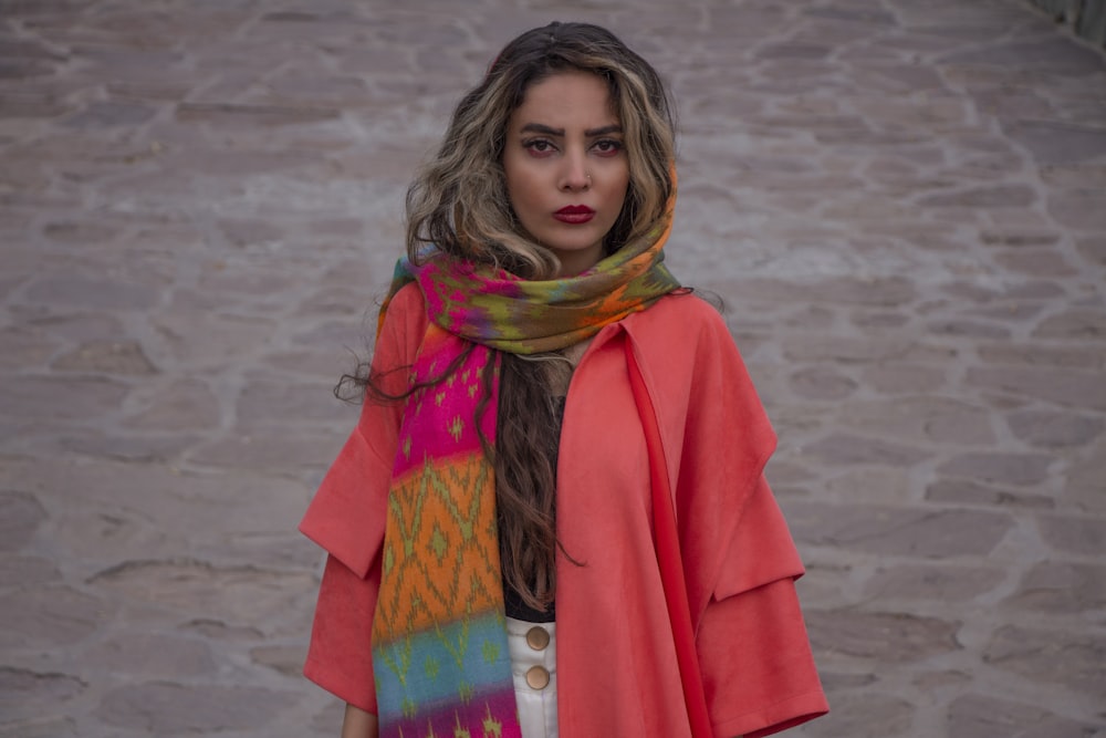 woman in red coat standing on white sand during daytime