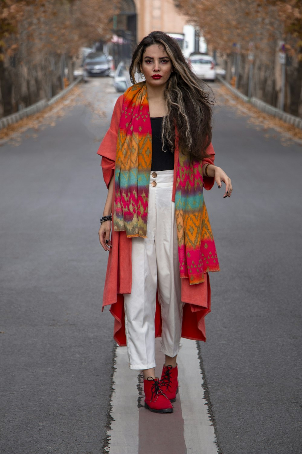 woman in red and white robe standing on road