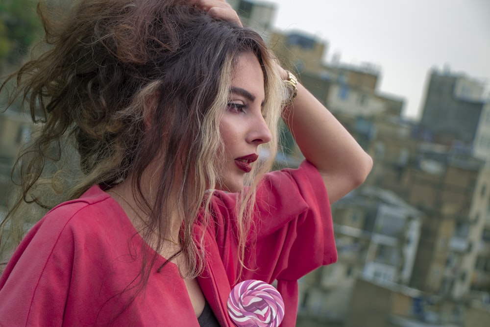 woman in pink shirt standing on top of building during daytime