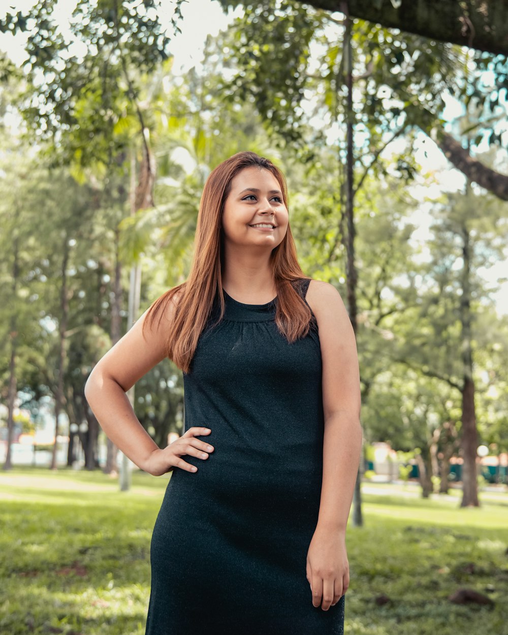 woman in black tank top standing on green grass field during daytime