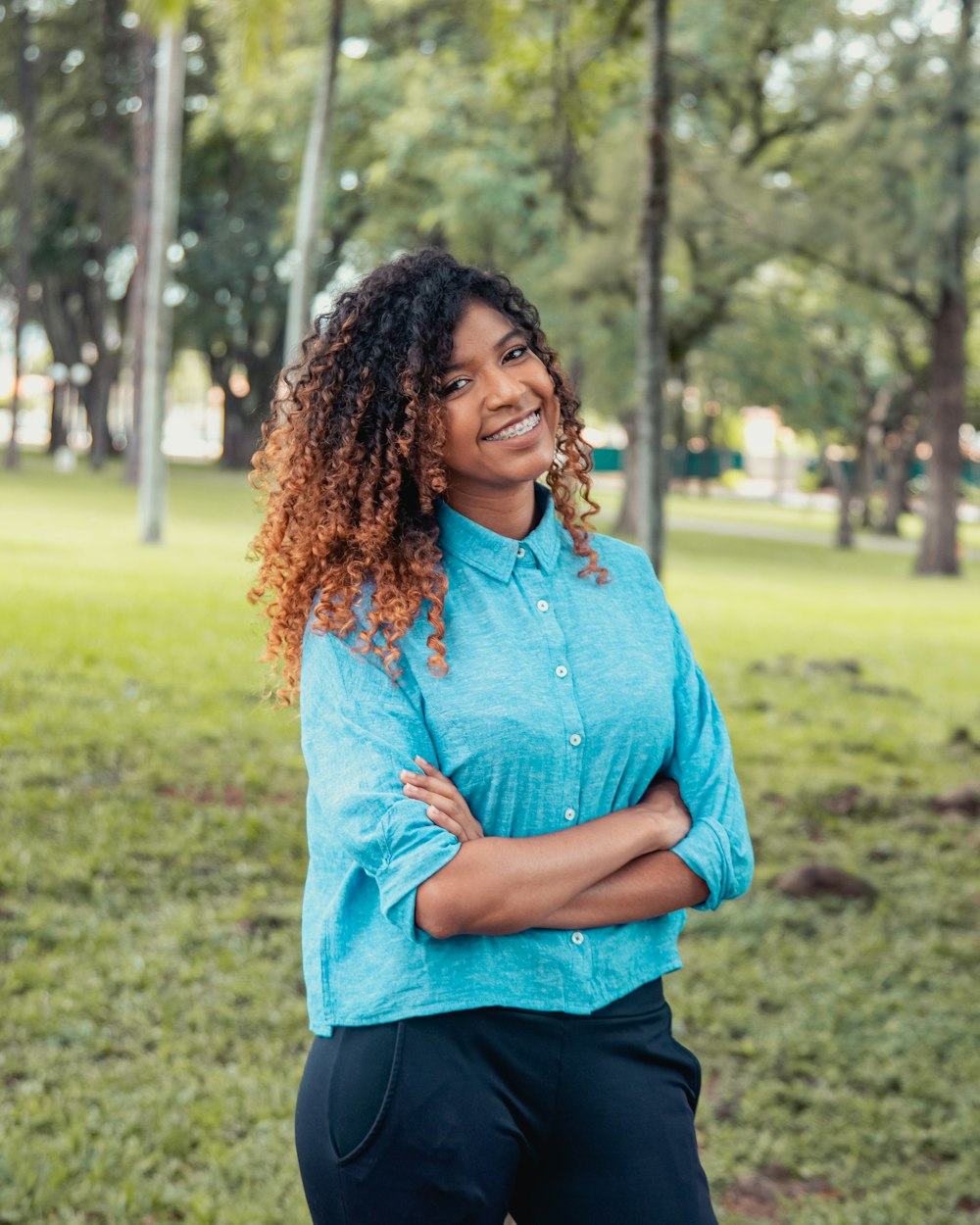 Femme en chemise à manches longues bleue debout sur le terrain d’herbe verte pendant la journée