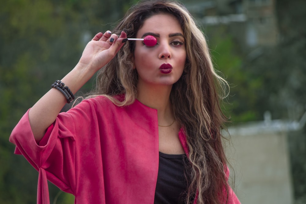 woman in red cardigan holding her hair