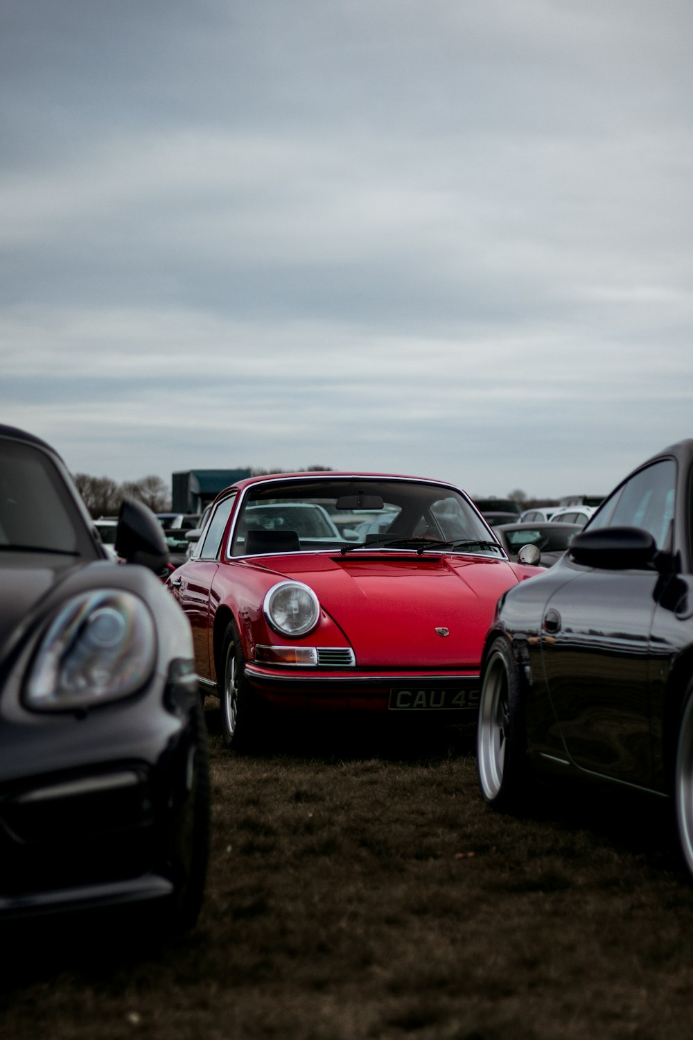 red porsche 911 on brown field during daytime