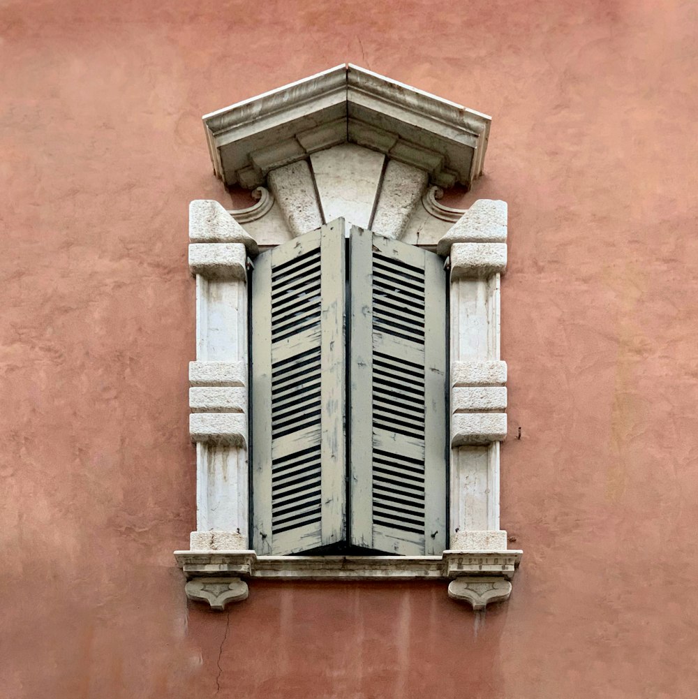 schwarzes Holzfenster an orangefarbener Betonwand