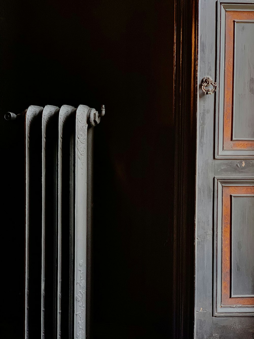 weißer Heizkörper neben brauner Holztür