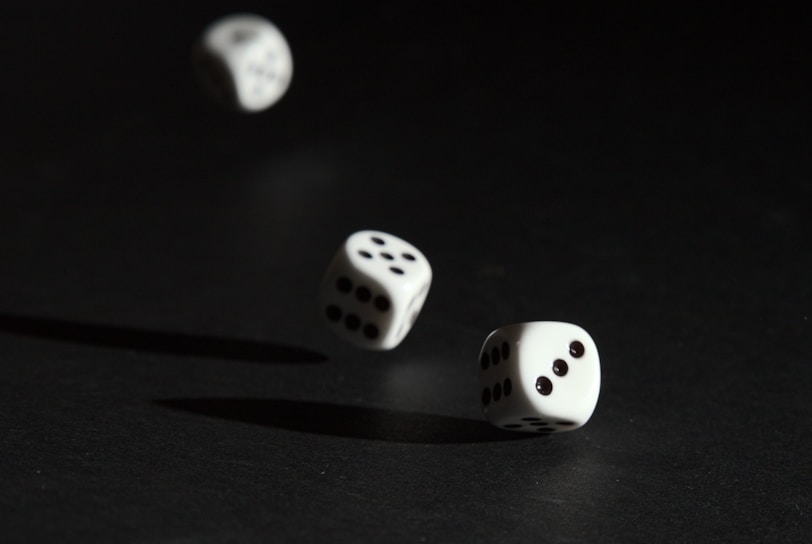 3 white dice on black surface