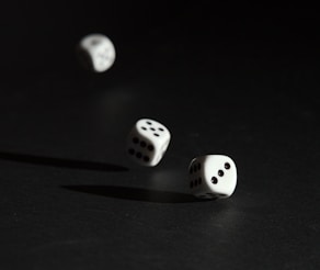 3 white dice on black surface