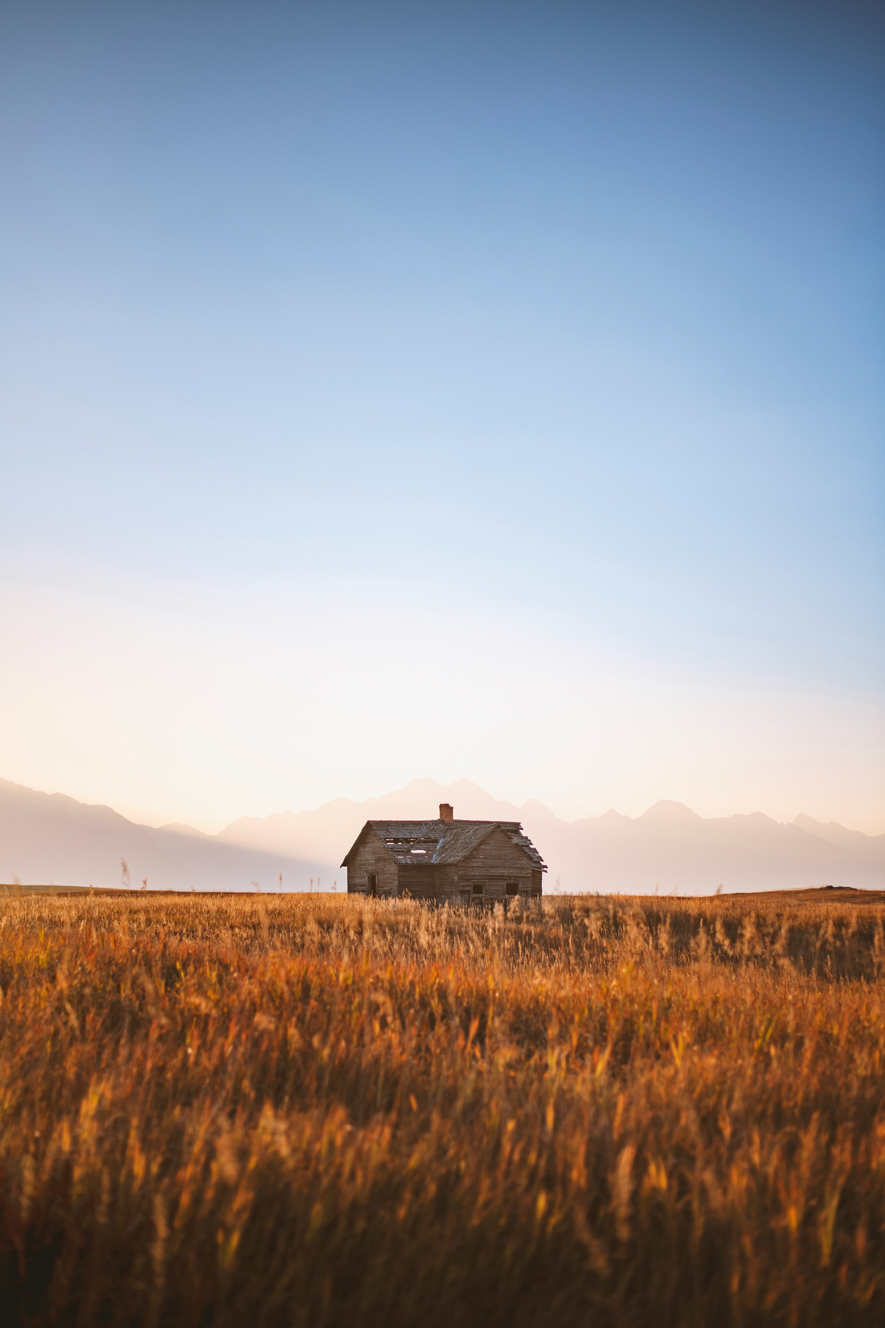 black wooden house on brown grass field during daytime