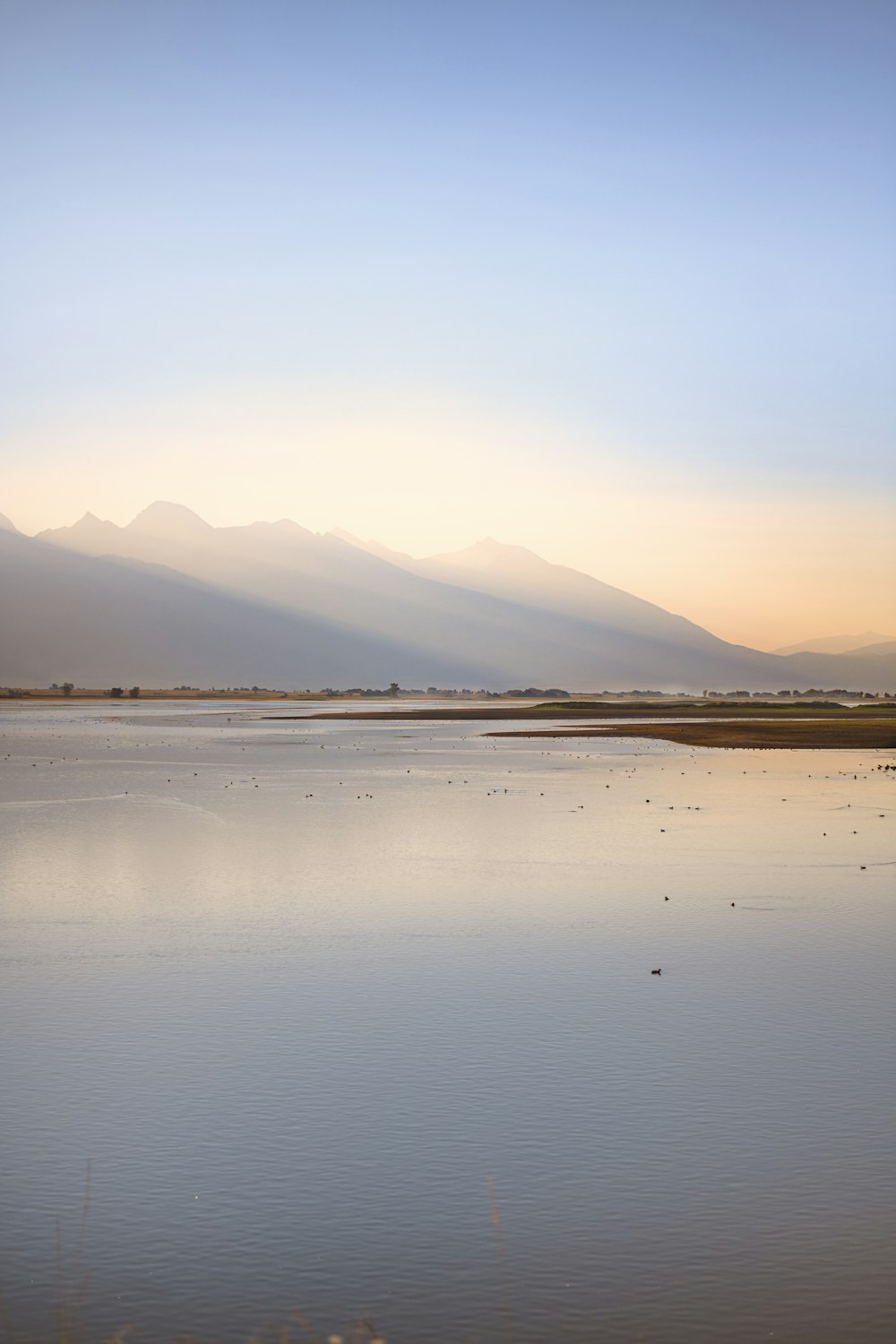 body of water near mountain during daytime