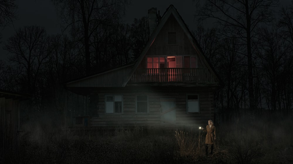 야간에 흰색과 빨간색 집 근처에 서있는 2 명