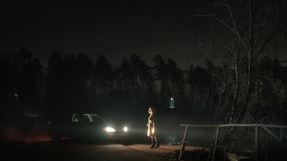 woman in white dress standing on road during night time