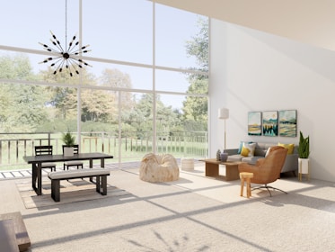 A spacious living room with large floor-to-ceiling windows overlooking a lush green garden. The room is furnished with a modern black dining table and chairs on the left, a cozy gray sofa with colorful cushions next to a wooden coffee table in the center, and a stylish brown armchair. Wall art adds a pop of color above the sofa, while a unique chandelier hangs from the ceiling. A floor lamp and lush potted plants enhance the ambience.