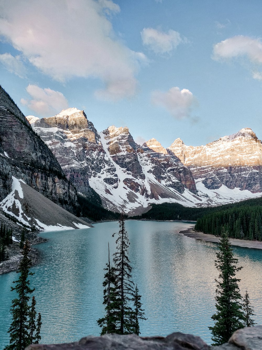 lake near snow covered mountain under blue sky during daytime