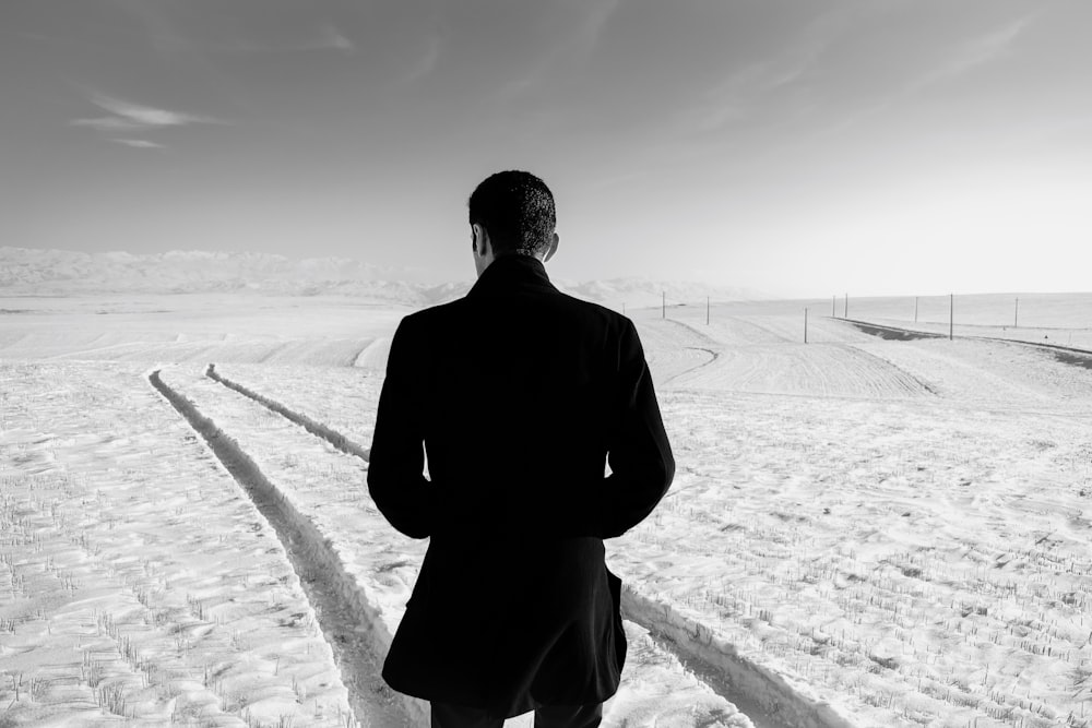 man in black suit standing on gray concrete pavement during daytime