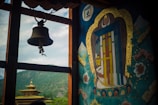 silver bell hanging on brown wooden post