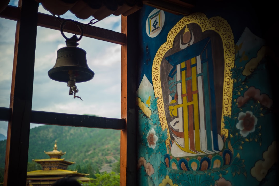 silver bell hanging on brown wooden post