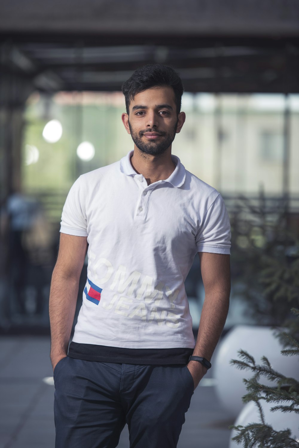man in white crew neck t-shirt standing on road during daytime