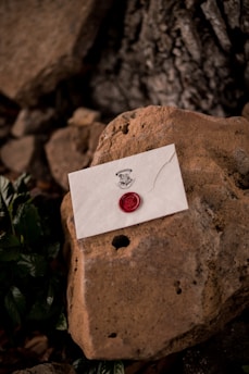 white and red heart card on brown stone