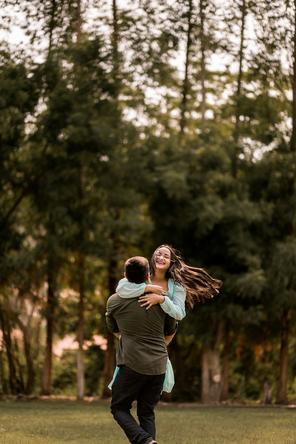 man and woman kissing in forest during daytime