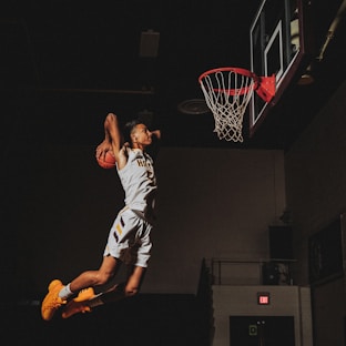 2 boys playing basketball on basketball court