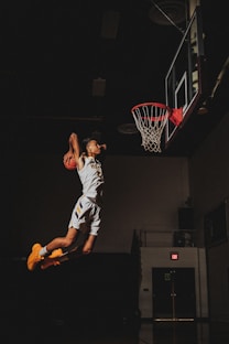 2 boys playing basketball on basketball court