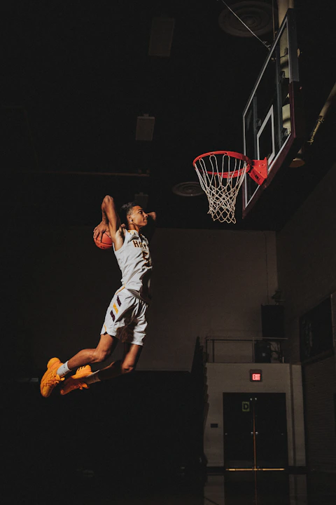 2 boys playing basketball on basketball court