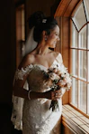 woman in white floral wedding dress holding bouquet of flowers
