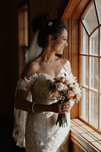 woman in white floral wedding dress holding bouquet of flowers