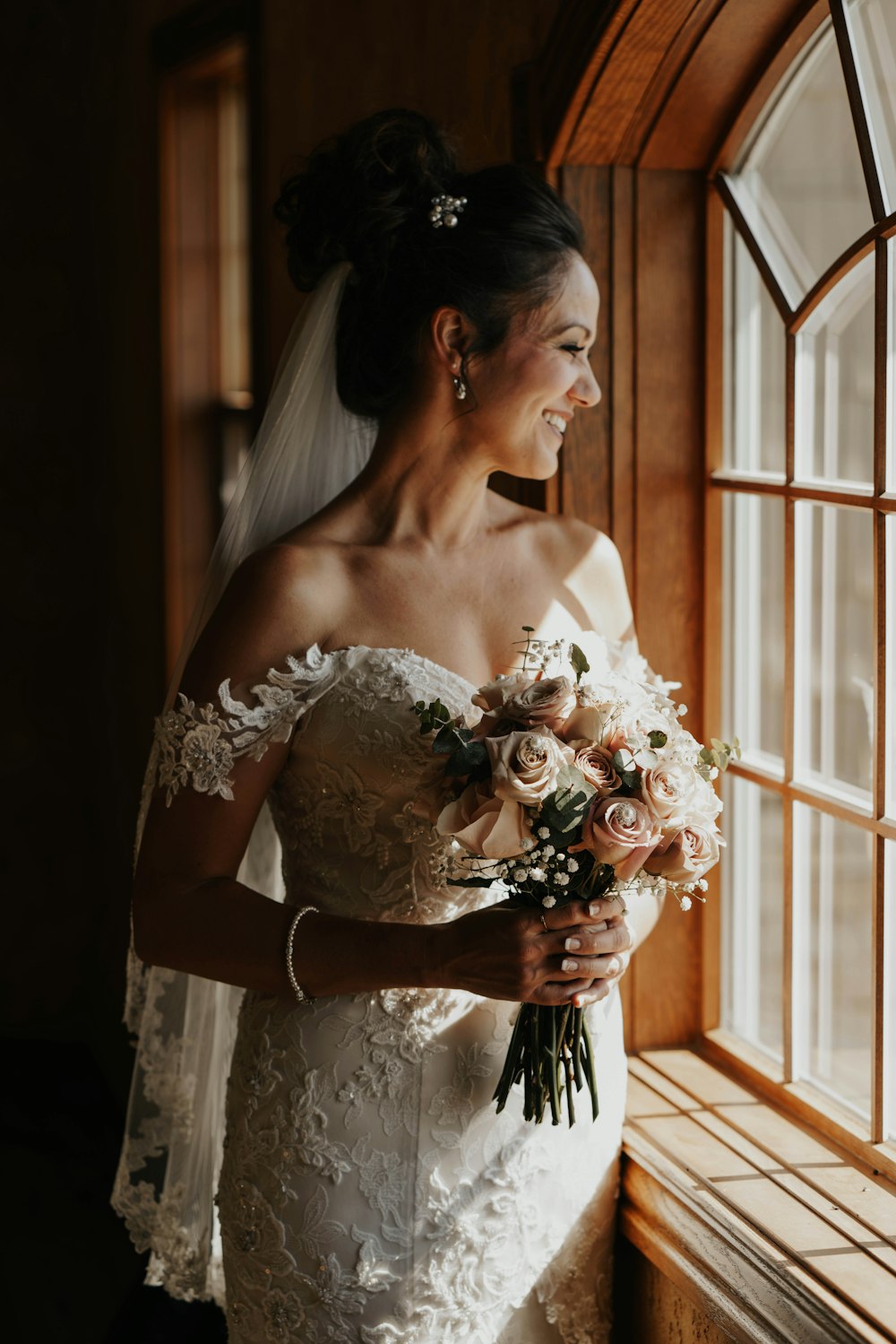 Frau in weißem geblümtem Brautkleid mit Blumenstrauß