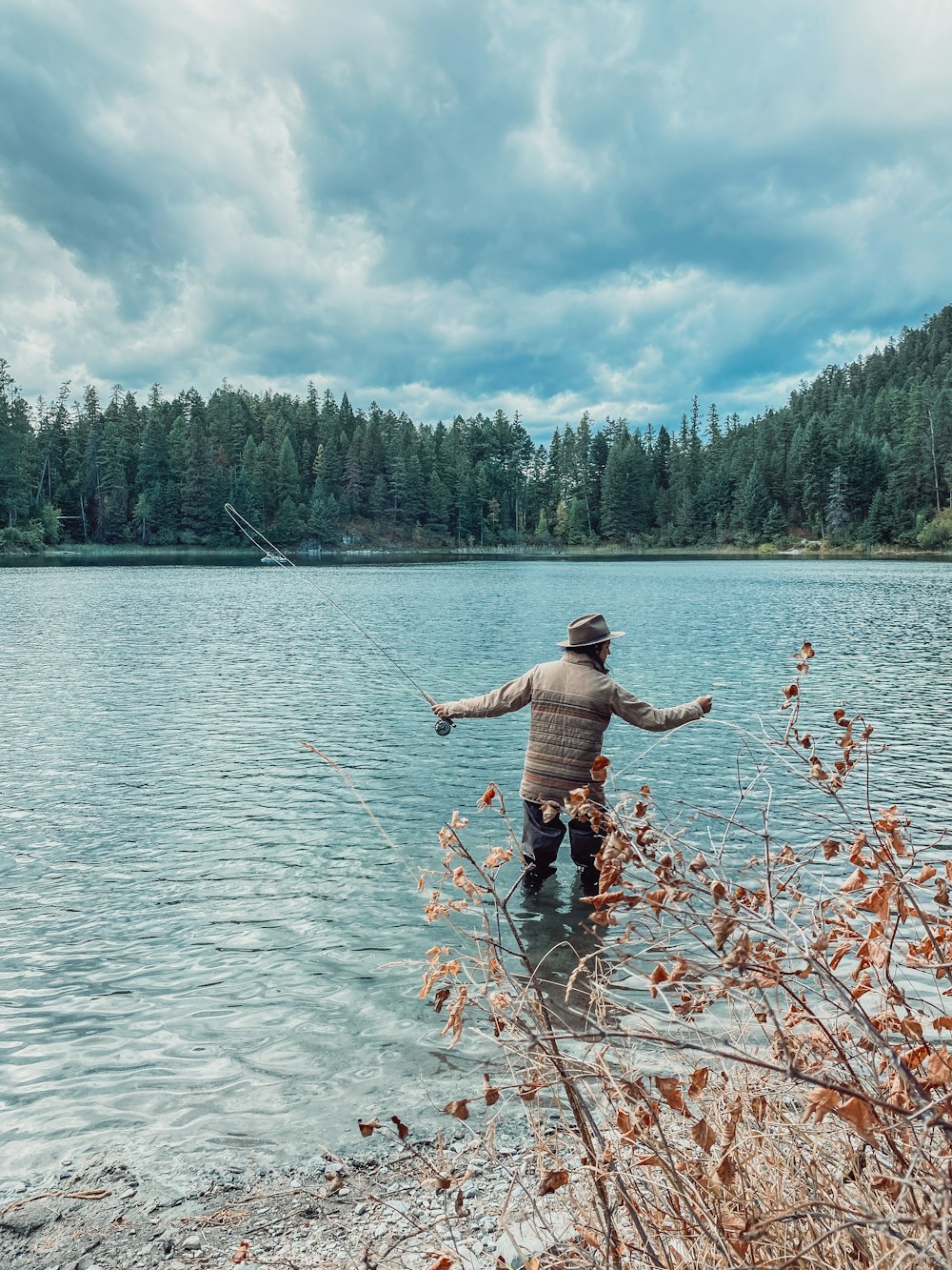 homem de shorts pretos em pé no corpo de água durante o dia