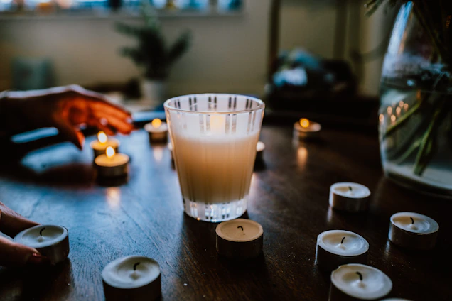 Cozy scene of handcrafted candles glowing softly on a wooden table with beige and turquoise accents.