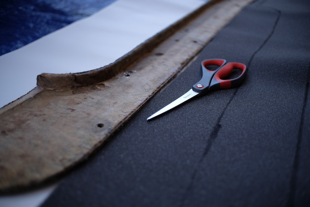 red handle scissors on blue and white textile