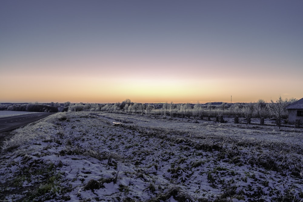 snow covered field during sunset