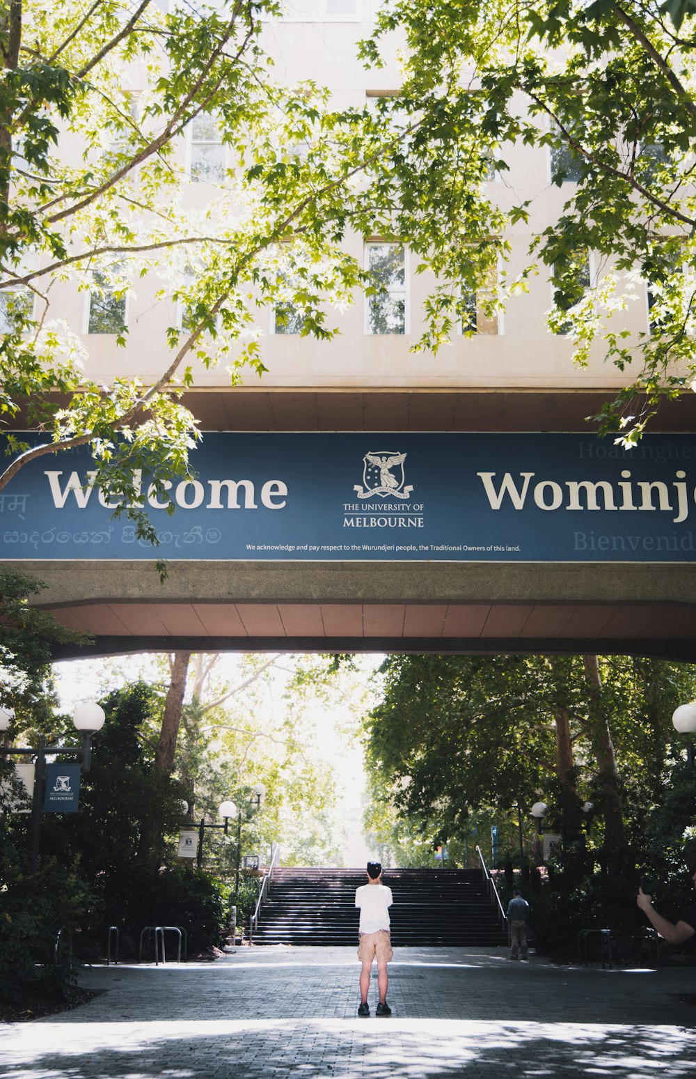 a person standing under a sign that reads welcome to wyoming