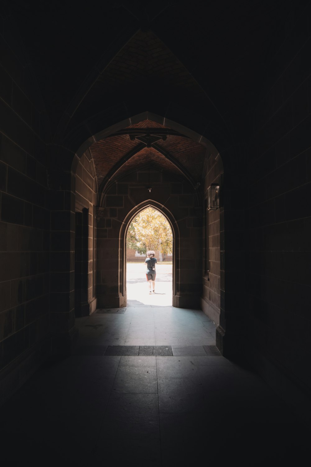 man in white shirt walking on tunnel