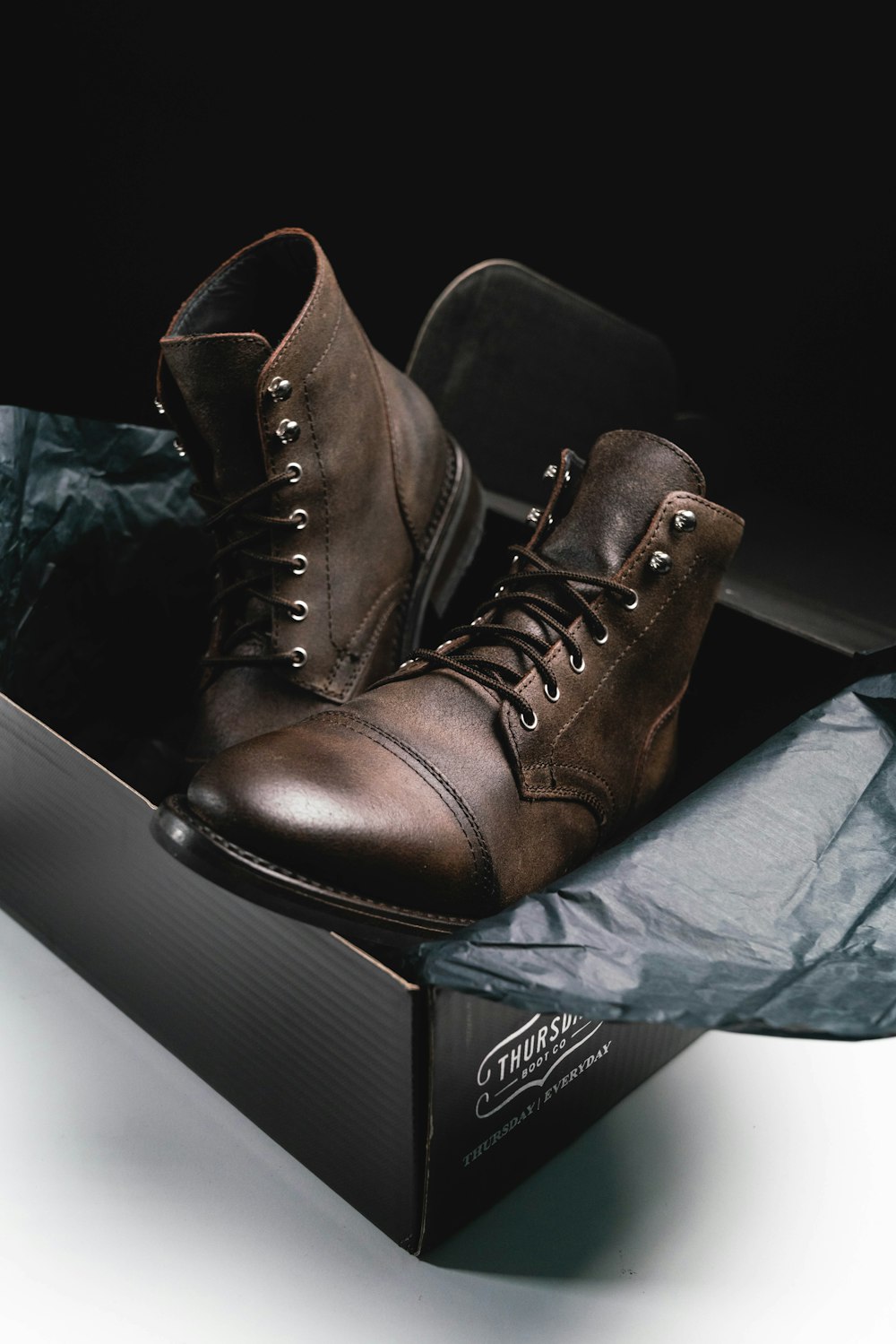 brown leather boots on black box
