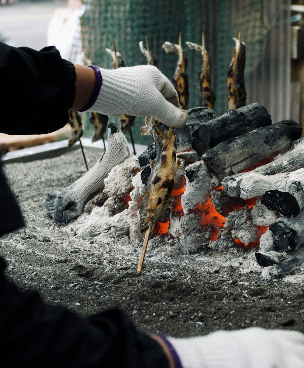 person in black long sleeve shirt holding brown stick with fire