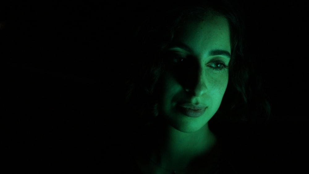 a woman in the dark looking at the camera