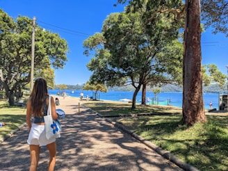 woman in white tank top and white shorts standing on brown concrete floor during daytime