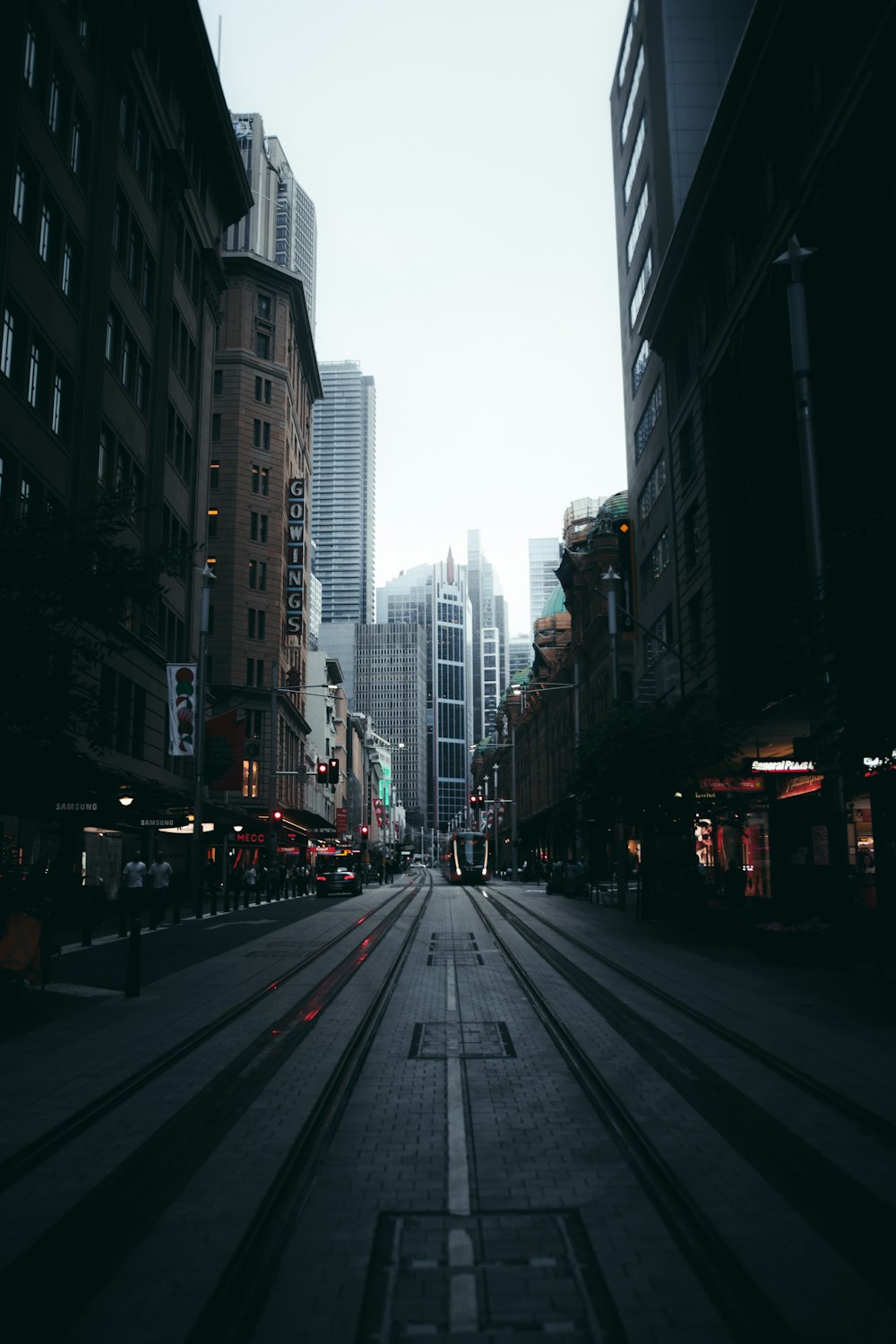 cars on road between high rise buildings during daytime