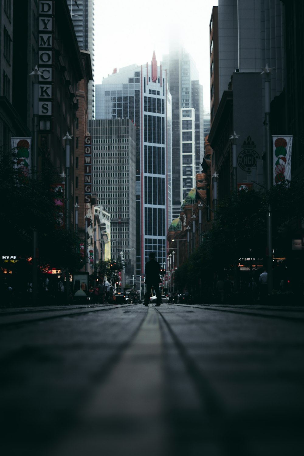 people walking on sidewalk near high rise buildings during daytime