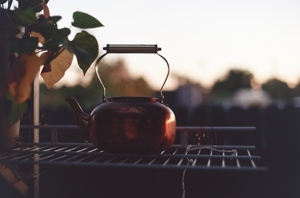 brown ceramic teapot on white metal rack