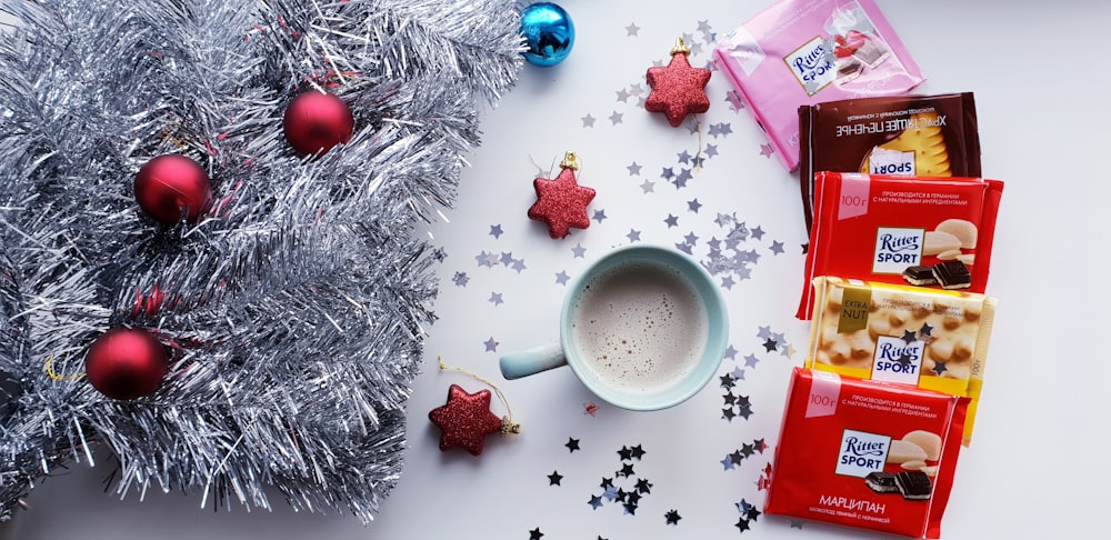 white and red ceramic mug beside red and white gift box