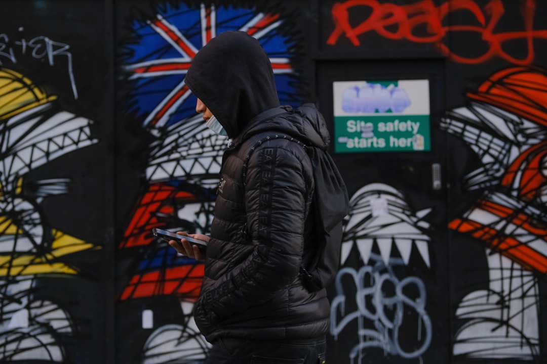 person in black leather jacket standing near black and white wall